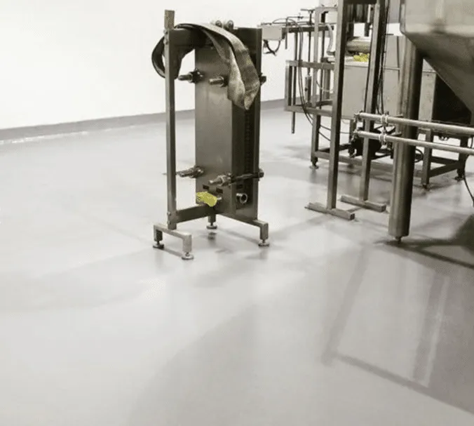 Coated floor beneath manufacturing equipment