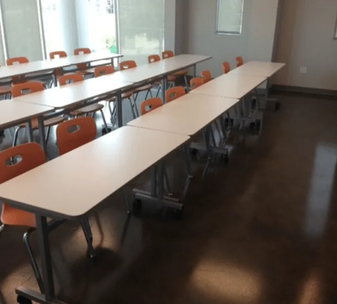 Long tables on a polished floor in a school space