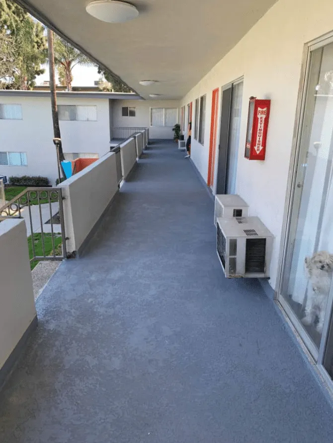 Gray coated exterior walkway along a multi-unit building
