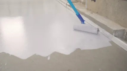 Epoxy coating being rolled onto a floor