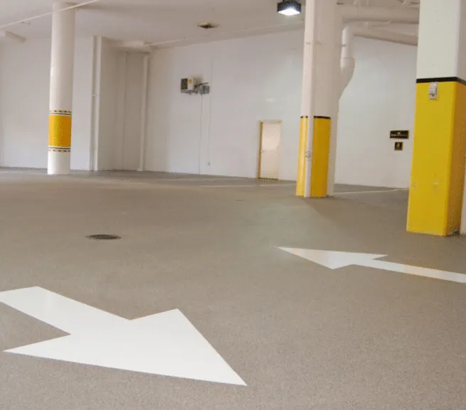 Parking area floor with painted arrows and yellow columns