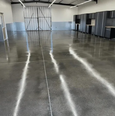 Polished gray concrete floor reflecting overhead lights